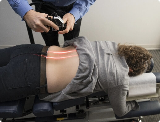 Dr. Todd administering cold laser therapy on a patient's lumbar spine